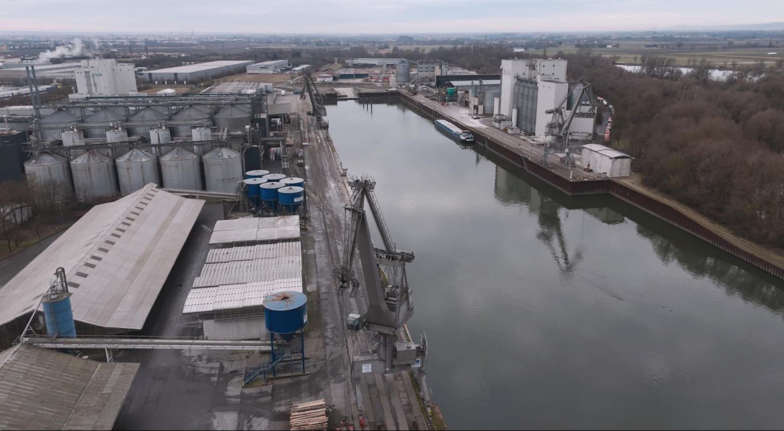 Drohnen-Luftbild eines Hafens mit Silos und Verladekränen